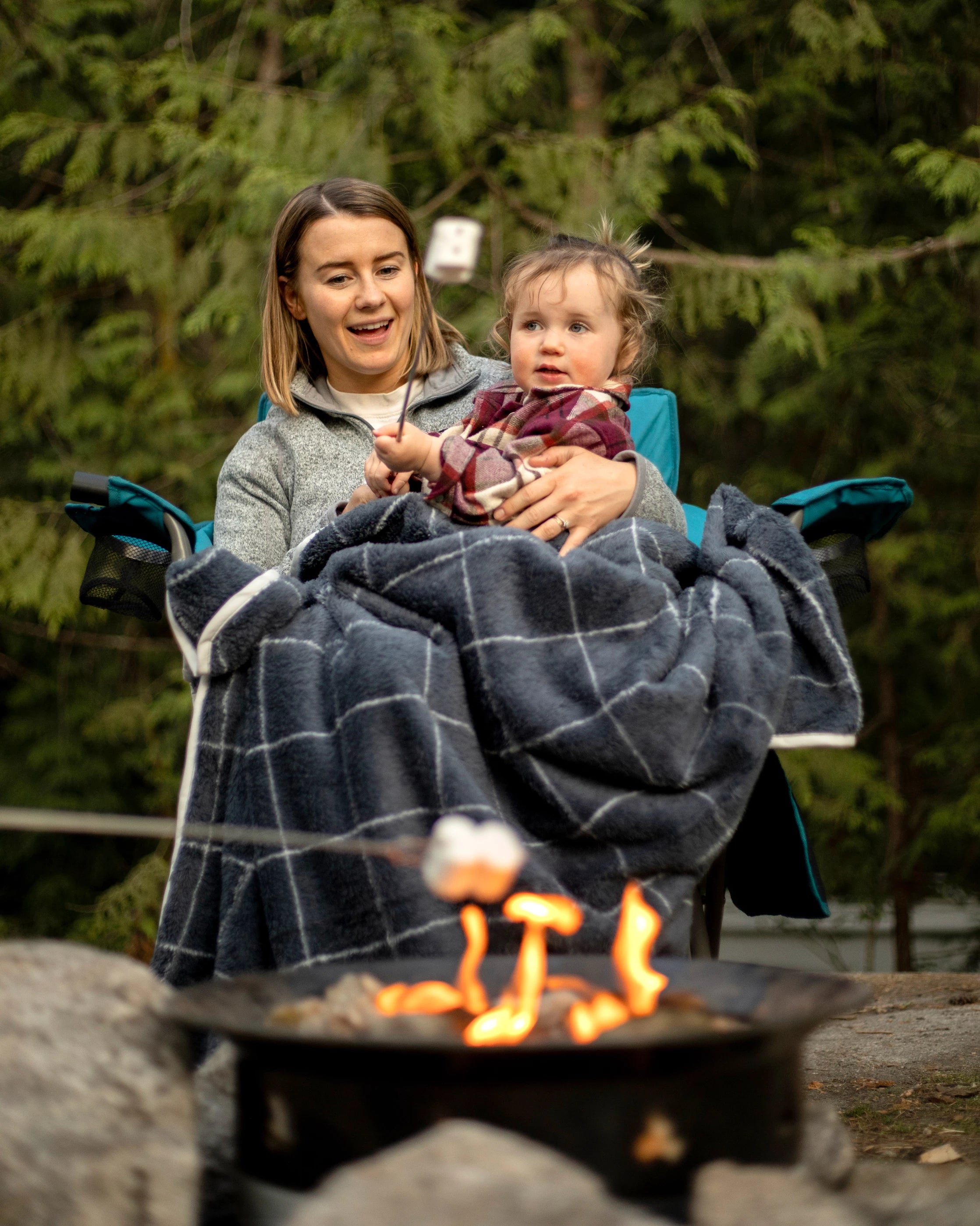Mother and toddler roasting marhsmallows over a fire